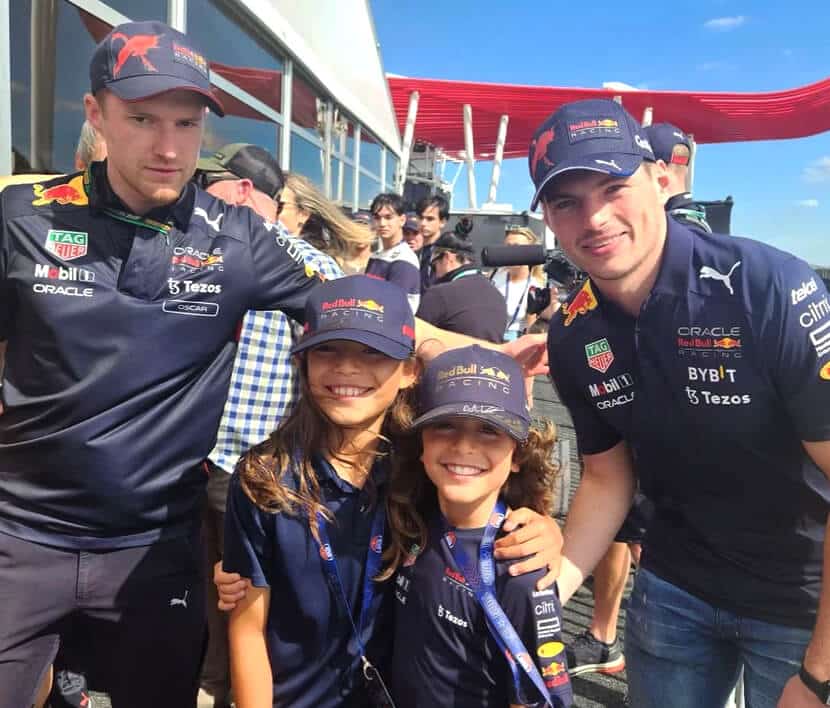 A male Dreamer and their sibling posing with F1 driver, Max Verstappen.