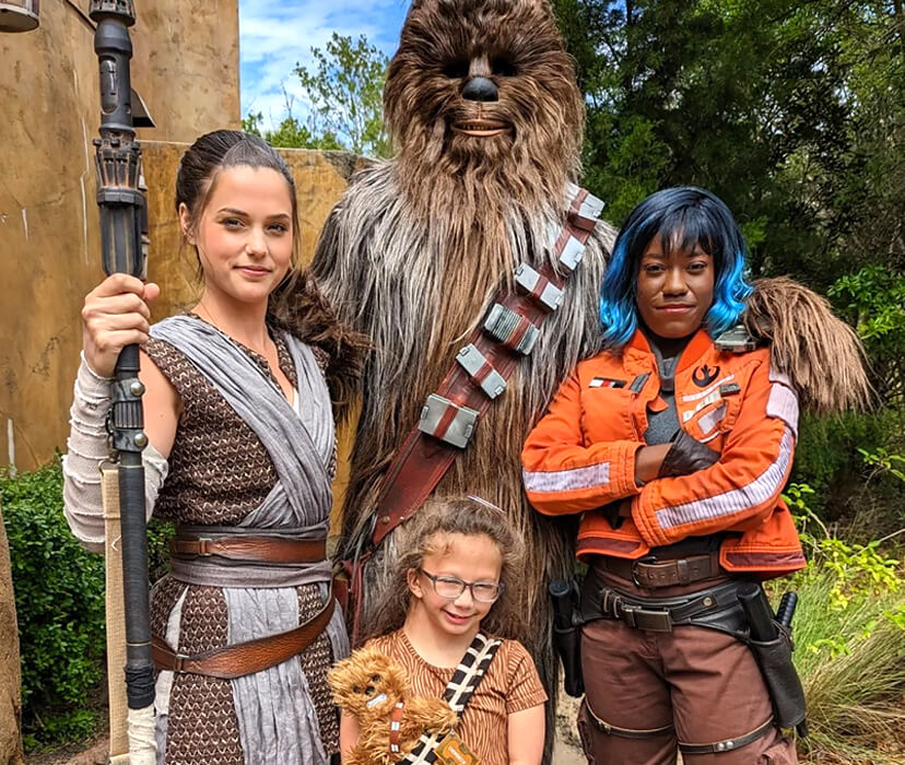 A Dreamer posing with characters from Star Wars at Disney.