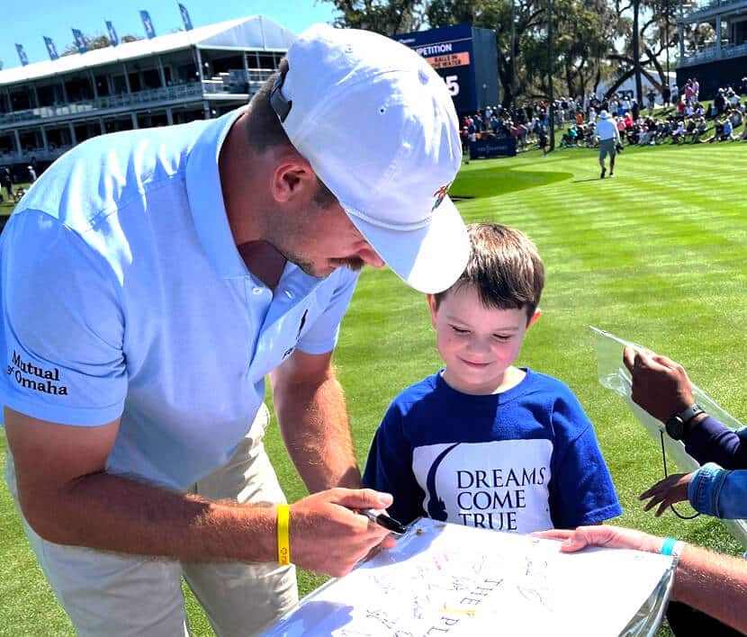 A male Dreamer getting an autograph from a professional golfer at The Players Championship.